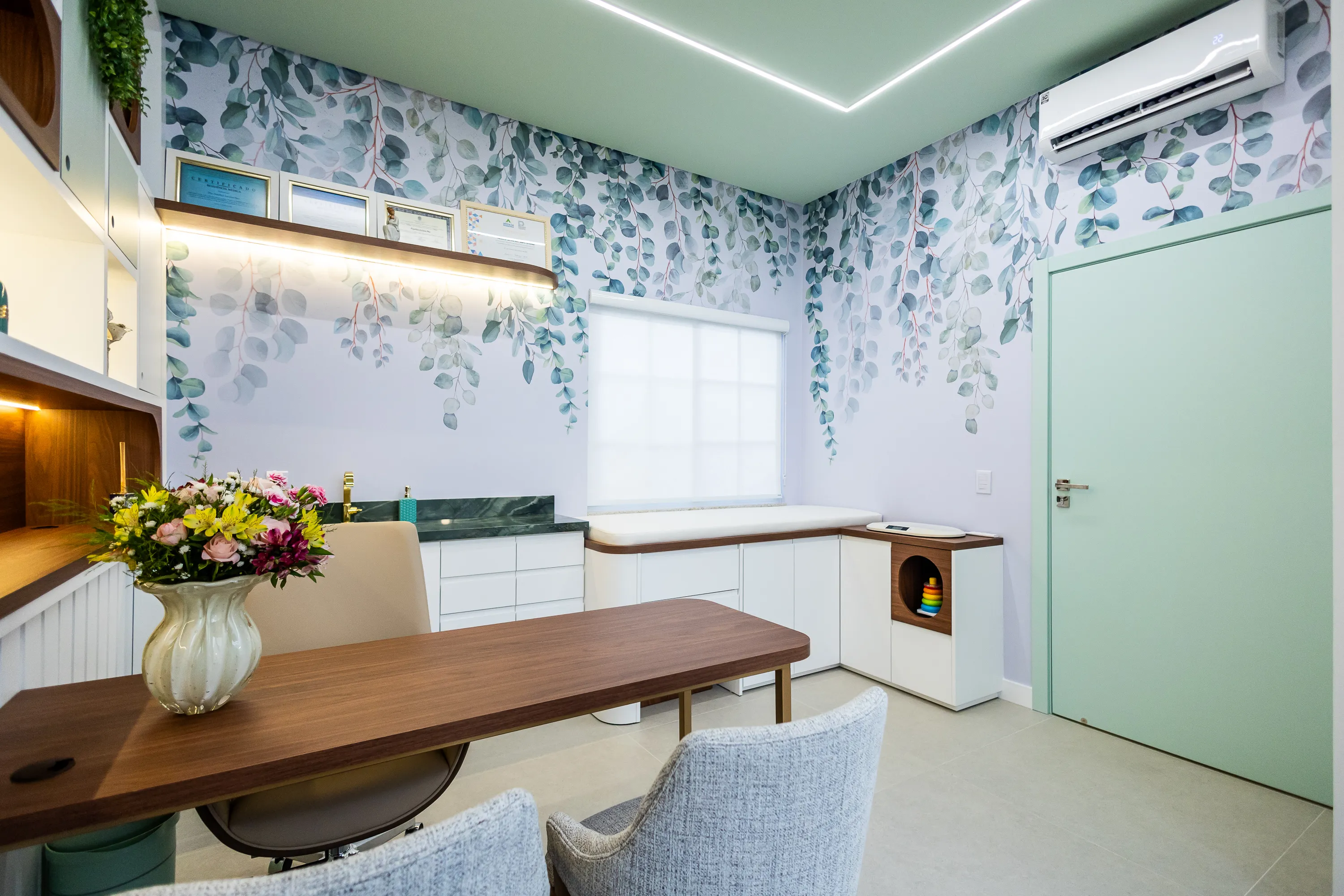 Consultório da Casalume — papel de parede botânico, porta verde menta e espaço infantil